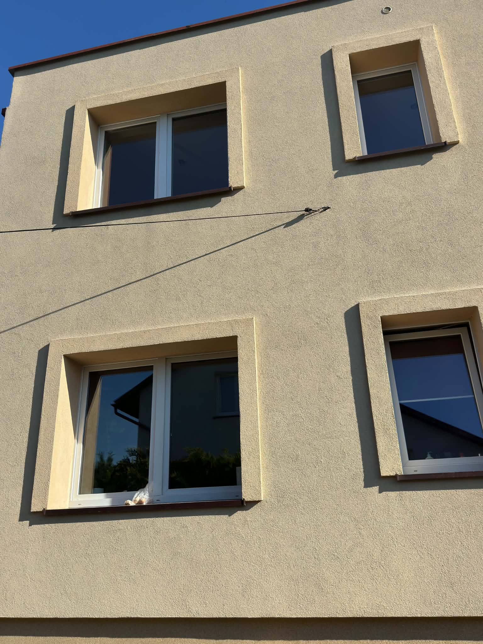Elewacja budynku w Czaplinku po myciu, ściana z oknami