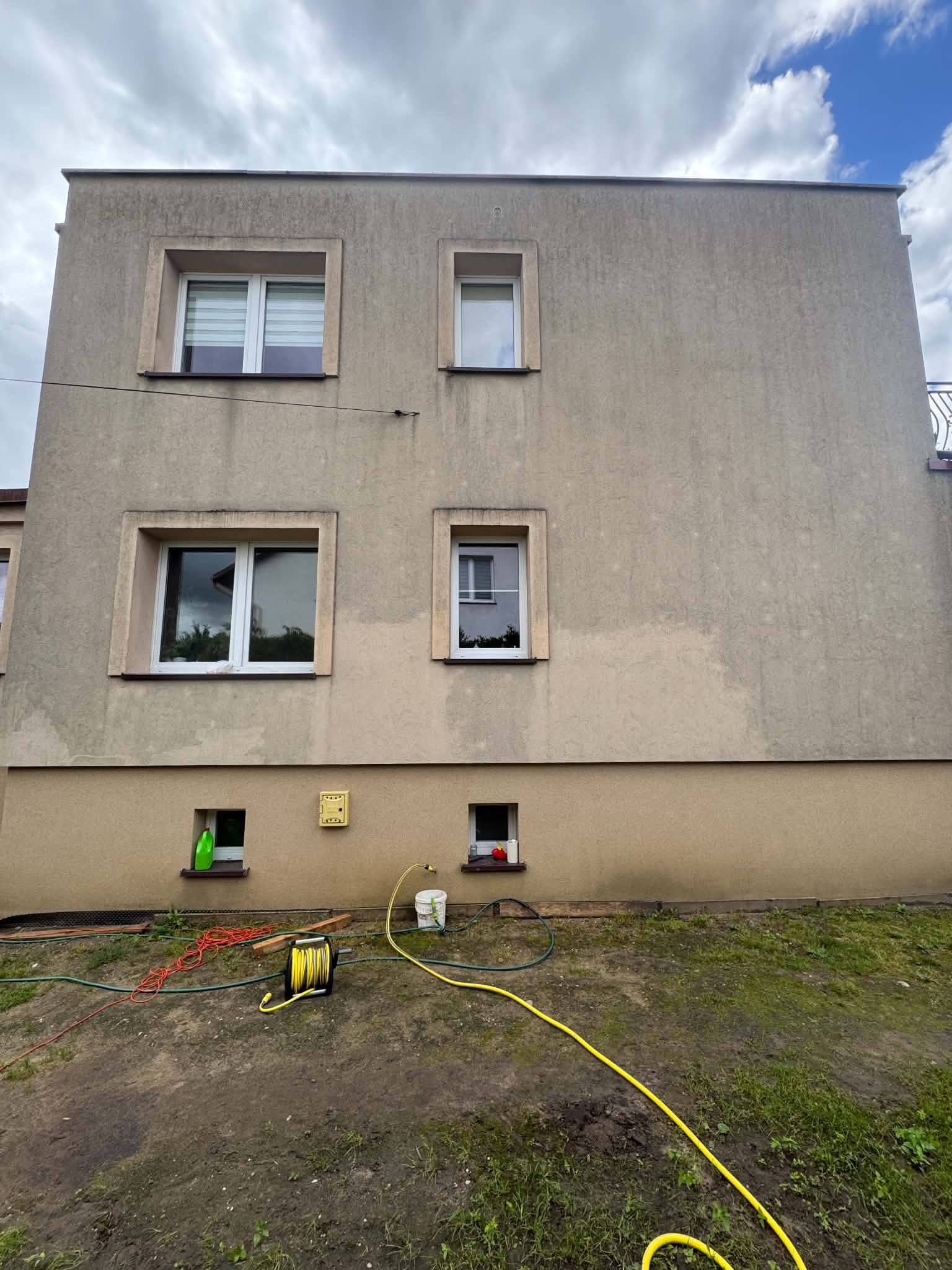 Elewacja budynku w Czaplinku przed myciem, ściana z oknami